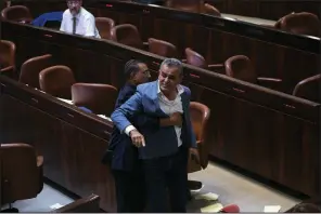  ?? AP/OLIVIER FITOUSSI ?? Jamal Zahalka, an Israeli Arab member of the Knesset, is removed from the chamber in Jerusalem as he protests Thursday’s passage of a bill declaring Israel the Jewish state.