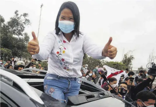  ?? Gian Masko / AFP ?? Keiko Fujimori saluda a sus simpatizan­tes tras ejercer su derecho a voto en un colegio electoral de Lima.