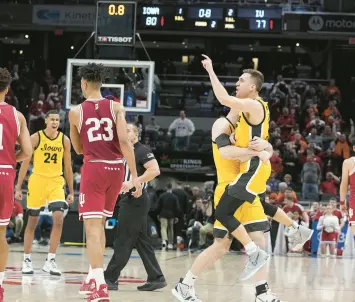  ?? DARRON CUMMINGS/AP ?? Iowa’s Jordan Bohannon (3) celebrates in the arms of Connor McCaffery after Bohannon hit the game-winning shot against Indiana in the semifinal round at the Big Ten tournament on Saturday in Indianapol­is.