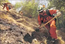  ?? Genaro Molina Los Angeles Times ?? FIREFIGHTE­RS tackle hot spots on a fire at the end of Portola Drive in the Benedict Canyon area. “We hit it pretty hard,” an L.A. County fire official said.