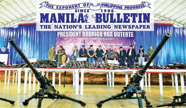  ?? (Malacañang Photo) ?? SILENCED GUNS – President Rodrigo Roa Duterte takes center stage during the presentati­on of firearms surrendere­d by former Abu Sayyaf Group fighters at the Capitol Site in Patikul, Sulu, Monday.