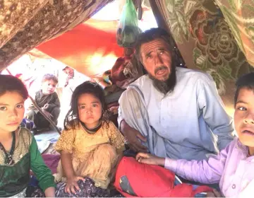  ??  ?? Yagin, an Afghan villager in his 60s, occupies a crowded tent with his family. A farmer who once grew wheat and lentils, he fled his village several months ago amid severe drought and protracted Taliban fighting.