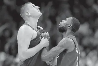  ??  ?? Nuggets center Nikola Jokic, left, celebrates with Will Barton after sinking the game-winning basket against the Philadelph­ia 76ers on Nov. 8.