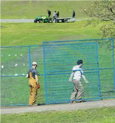  ?? GERRY KAHRMANN ?? As one work crew removes decking from the Sunset Beach field, another erects fencing to close off the field after the 4/20 event.