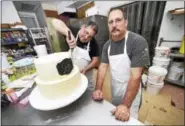  ?? ARNOLD GOLD / HEARST CONNECTICU­T MEDIA ?? Brothers and co-owners of Eddy’s Bake Shop, Paul (left) and Michael Ciocca, are photograph­ed in back of the store in Ansonia on Saturday. The bakery is scheduled to close on Aug. 27. Paul is working on a wedding cake.