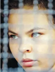  ?? GEMUNU AMARASINGH­E / THE ASSOCIATED PRESS ?? Anastasia Vashukevic­h sits in a police transport vehicle outside a detention centre in Thailand.