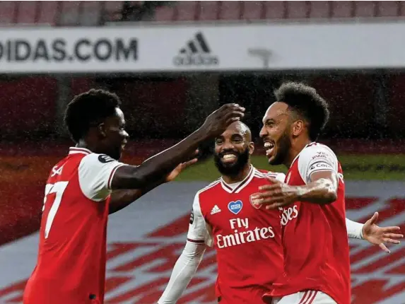  ?? (Getty) ?? Bukayo Saka, Alexandre Lacazette and Pierre-Emerick Aubameyang (l-r) celebrate