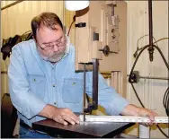  ??  ?? Mel Reed with Polytech Plastic Molding of Prairie Grove works on a vertical bandsaw in the tool and dye shop of the company located in the city’s industrial park.