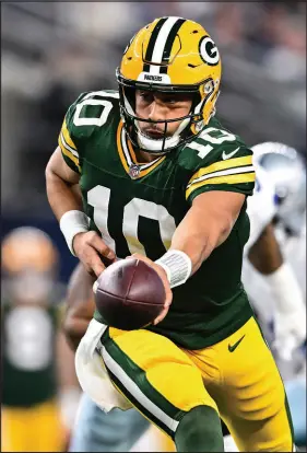  ?? MARIA LYSAKER / ASSOCIATED PRESS ?? Green Bay Packers quarterbac­k Jordan Love looks to hand off the ball during a 48-32 upset of the Dallas Cowboys in a wild-card game Sunday in Arlington, Texas. Love has not thrown an intercepti­on in five consective games and just one in his last nine contests.