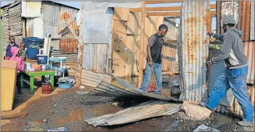  ?? PICTURE: LOYISO DYONGMAN ?? ON THE MOVE: Silvertown residents destroying their shacks to get rid of sewage which flowed into them