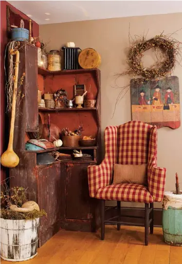  ??  ?? Below: In the dining room corner, Ellie gathers wooden bowls, firkins, buckets, candle molds and other vintage-inspired pieces to make a cozy nook. A worn painted barrel was repurposed as a side table. 35