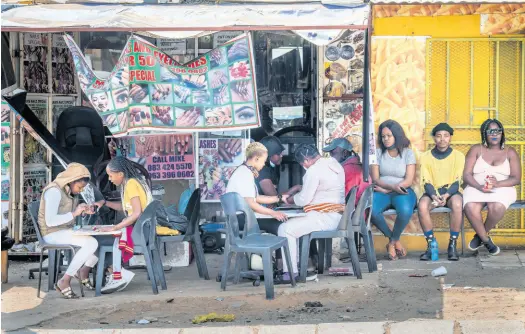  ?? AP ?? Customers have their nails done near the Baragwanat­h taxi rank in Soweto, South Africa on Wednesday.