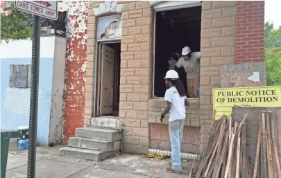  ?? PHOTOS BY MELANIE EVERSLEY, USA TODAY ?? Employees from Baltimore’s Details deconstruc­t a derelict home with an eye toward reselling the valuable wood and other components. Workers say the job gives them a sense of purpose and belonging.