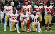  ?? AP PHOTO BY DAVID J. PHILLIP ?? San Francisco 49ers San Francisco 49ers’ Eli Harold (57), Eric Reid (35) and Marquise Goodwin (11) kneel during the national anthem before an NFL football game against the Houston Texans, Sunday, Dec. 10, 2017, in Houston.