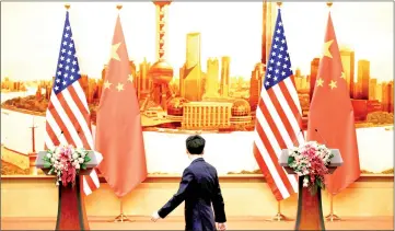  ?? — Reuters photo ?? File photo shows a staff member walks past US and Chinese flags placed for a joint news conference by US Secretary of State Mike Pompeo and Wang Yi at the Great Hall of the People in Beijing.