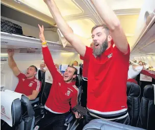  ??  ?? ■ Joe Ledley leads the singing during Wales’ flight home from Bosnia, the scene of their Euro qualificat­ion confirmati­on