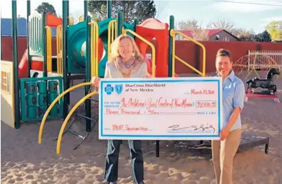  ??  ?? Jade Richardson Bock, left, accepts a check from Consuelo Bolagh Cowder of BCBSNM.