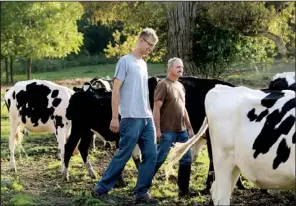  ??  ?? AP/HEATHER AINSWORTH
Dan Dimon herds cows with his father-in-law, Kevin Carley, at The Carley Farms in Pompey, N.Y. Dimon is buying the dairy and agricultur­al farm in phases because, he, like many young farmers, can't raise enough money to purchase...