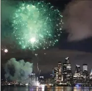  ?? KATHY WILLENS - ASSOCIATED PRESS ?? A surprise display of fireworks sponsored by Macy’s explode over the Hudson Yards area of Manhattan as seen from a pier in Hoboken, N.J., late Tuesday. The fireworks were not announced until an hour or so before to avoid attracting large crowds.