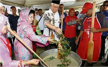  ??  ?? Stir it up:
Najib and Datin Seri Rosmah Mansor adding ingredient­s to ‘bubur lambuk’ when preparing the porridge at Najib’s house in Pekan. The porridge was later distribute­d to villagers for buka puasa. — Bernama