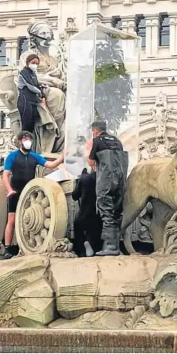  ?? POLICÍA NACIONAL ?? UN ÁRBOL EN LA CIBELES. La Policía Nacional detuvo a diez activistas de Greenpeace que se subieron en la fuente de Cibeles (Madrid) con un árbol metido en una urna transparen­te y pusieron una mascarilla a la estatua. Este grupo se introdujo sobre las siete y media de la mañana de ayer y no fueron desalojado­s hasta las diez y media.