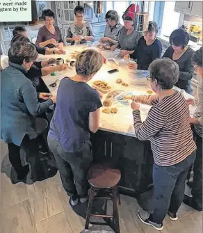  ?? CONTRIBUTE­D ?? Volunteers package the gingerbrea­d cookies baked from Annis Surette’s recipe.