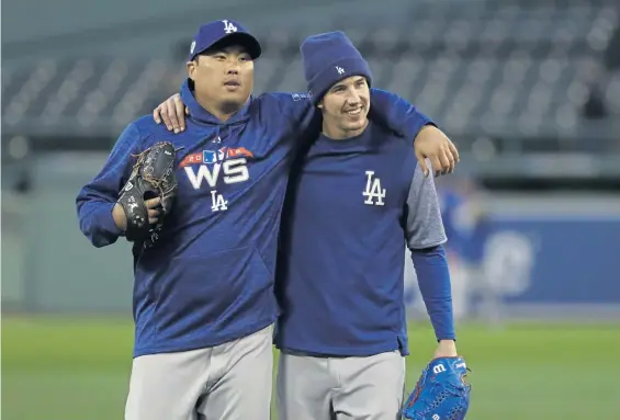  ?? ASSOCIATED PRESS ?? A GOOD ONE TO FOLLOW: Walker Buehler (right) hugs Game 2 starter and Dodgers teammate Hyun-jin Ryu during Monday’s workout at Fenway. Buehler gets the start when the World Series shifts to Los Angeles for Game 3 tomorrow.