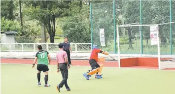  ??  ?? One XOX captain Anderson Sigat lobs the ball over Eleven Warrior goalie M Khairul Hanafi in the Men’s Open final’s penalty shootout at Sarawak Hockey Stadium.