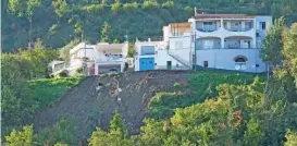  ?? (AFP) ?? Houses remain precarious­ly on the edge of a landslide in Casamiccio­la on Sunday, following heavy rains on the island of Ischia, southern Italy