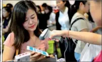  ?? XINHUA ?? A woman uses Alipay, a business of Ant Financial, via her mobile phone at a store in Singapore.