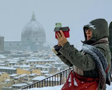  ?? (foto: Cambi/Sestini) ?? Una vista diversa dal Piazzale su Firenze innevata, a destra le «pallate» tra i ragazzi