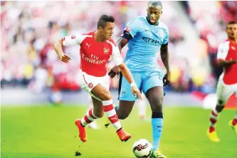  ??  ?? Arsenal striker Alexis Sanchez goes past Manchester City’s Yaya Toure during one of their English Premier Lweague matches.