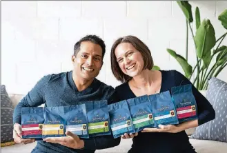  ??  ?? Kait Brown, right, and her partner and spouse, Daniel, show off their varieties of decaf and “half-caf” coffees. Brown started Savorista LLC in 2018 after searching the globe for a full flavored decaffeina­ted coffee.