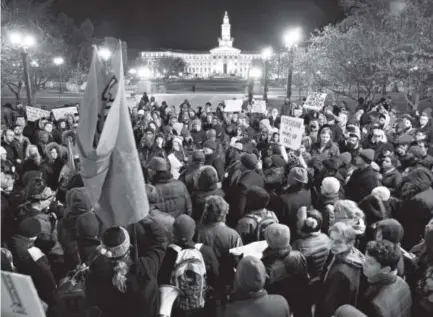  ??  ?? About 300 protesters on Tuesday night gather near Civic Center, between the Capitol and the City and County Building, in the background. They marched through downtown to the Denver jail. Photos by John Leyba, The Denver Post