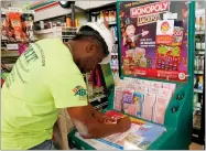  ?? AP PHOTO BY JOHN RAOUX ?? Jean Pierre fills out several Mega Millions lottery tickets for purchase at a convenienc­e store Monday, Oct. 22, in Orlando, Fla.