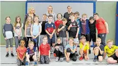  ?? BILD: HIBBELER ?? Lehrerin Rita Fischer sowie die VfL-Handballer­innen AnnKristin Roller und Myrthe Schoenacke­r mit den Kinder der Grundschul­e Unter dem Regenbogen.