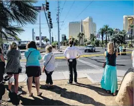  ?? Marcus Yam Los Angeles Times ?? TOURISTS VISIT the crime scene in Las Vegas one day after the Oct. 1 shooting. “We don’t feel safe until we know” the motive, one psychologi­st says.