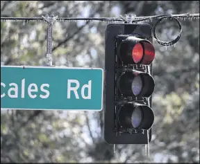  ?? HYOSUB SHIN / HSHIN@AJC.COM ?? Icicles form on a traffic light on Scales Road in Suwanee on Saturday. Snow fell in parts of Georgia on Friday night, but much of metro Atlanta got very little or no snow at all.