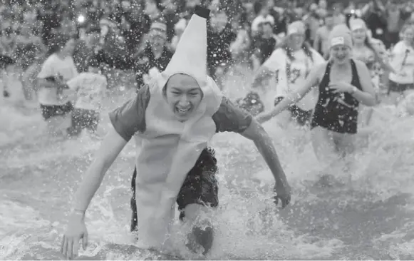  ?? STEVE RUSSELL PHOTOS/TORONTO STAR ?? Oakville’s Courage Polar Bear Dip is the largest event of its kind for charity in Canada. It was started in 1985 by Gaye Courage and her sons, and now draws hundreds of participan­ts each year.