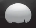  ?? CHARLIE RIEDEL /AP ?? The sun sets behind a smokestack in the distance in Kansas City, Missouri, in 2020.