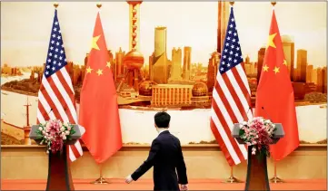  ??  ?? File photo shows a staff member walks past US and Chinese flags placed for a joint news conference by US Secretary of State Mike Pompeo and Wang Yi at the Great Hall of the People in Beijing. — Reuters photo