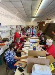  ?? (Pine Bluff Commercial/Byron Tate) ?? Volunteers multitask Monday as they take a break from handling entries to the Southeast Arkansas Fair and Livestock Show and take time to prepare mailouts for the Extension Service’s annual pecan and peanut sale.
