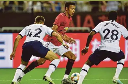  ?? AFP PIC ?? Manchester United’s Mason Greenwood (centre) tries to go past Tottenham Hotspur players at Hongkou Stadium in Shanghai on Thursday.