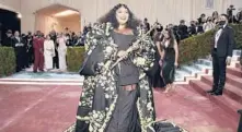  ?? EVAN AGOSTINI/ INVISION ?? Lizzo played her gold flute as she walked the red carpet May 2 in a look by Thom Browne at the Metropolit­an Museum of Art’s Costume Institute benefit gala.