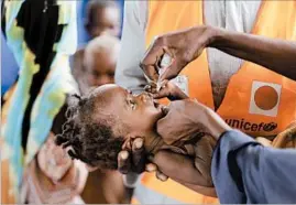  ?? SUNDAY ALAMBA/AP ?? A toddler receives a polio vaccine at a camp for people displaced by Islamic extremists in Maiduguri, Nigeria. Health workers vaccinated 1.5 million children in the past week.