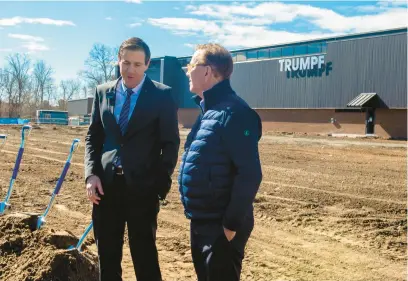  ?? AARON FLAUM/HARTFORD COURANT ?? Lutz Labisch, left, president and CEO of Trumpf Inc., talks with Gov. Ned Lamont after a groundbrea­king for the 56,000 square-foot expansion at Trumpf in Farmington on Thursday.