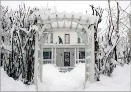  ?? DARYN SLOVER/SUN JOURNAL VIA AP ?? AMBER COX SHOVELS THE PORCH ROOF AT HER HOME in Auburn, Maine, on Thursday. The second major storm in less than a week is moving up the East Coast, dumping heavy snow and knocking out power to hundreds of thousands of homes and businesses from...