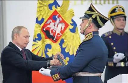  ?? / MIKHAIL SVETLOV (GETTY) ?? El presidente Vladímir Putin saca una medalla de un cofre durante una ceremonia de entrega de premios con motivo del Día de Rusia, el miércoles en el Kremlin.