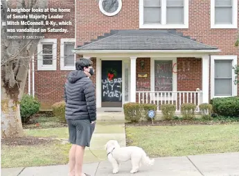  ?? TIMOTHY D. EASLEY/ AP ?? A neighbor looks at the home of Senate Majority Leader Mitch McConnell, R- Ky., which was vandalized on Saturday.