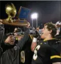  ?? DIGITAL FIRST MEDIA FILE PHOTO ?? Archbishop Wood coach Steve Devlin hoists the PIAA Class AAA championsh­ip trophy for all to see after the victory over Central Valley at Hershey Stadium Friday, Dec. 12, 2014.